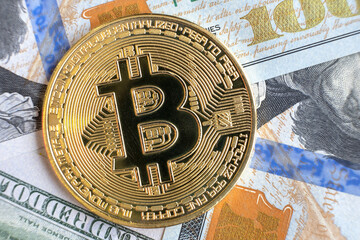 Fototapeta na wymiar Close up of metal shiny bitcoin crypto currency coin on US dollar bills. Electronic decentralized money concept.