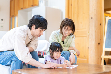 家でお勉強をする女の子と両親