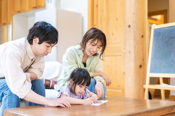 家でお勉強をする女の子と両親