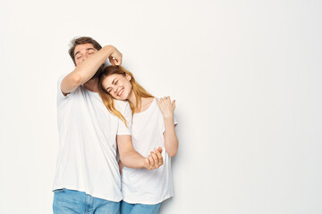 joyful man and woman in white t-shirts embrace friendship together