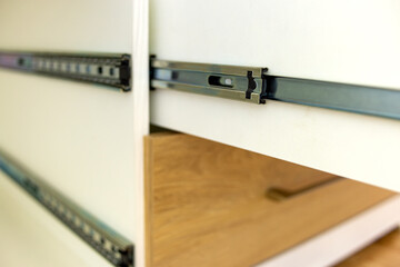 Close up of installation of wooden drawer in contemporary cupboard cabinet.