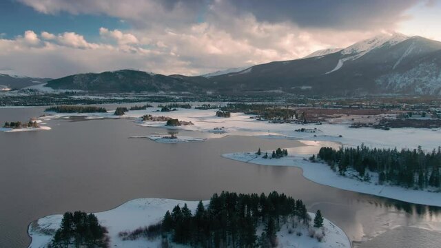Aerial: Islands and forest covered in snow in Dillon Reservoir. Frisco, Colorado, USA