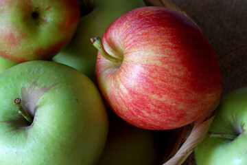 green and red apples in a wicker basket