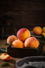 Vertical shot of fresh peaches on a wooden table © Mae Mu/Wirestock