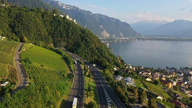 Aerial drone footage of the highway above Montreux leading to the Glion tunnel by lake Geneva in Canton Vaud in summer in Switzerland with a forward motion