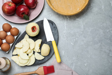 Cut fresh apple with knife on grey table, flat lay and space for text. Baking pie