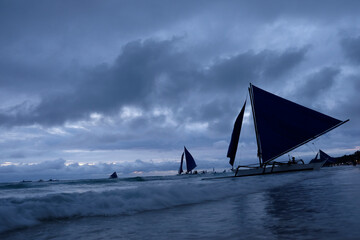 Fototapeta na wymiar sailboat and sea wave at beach. Evening clouds in sky. At Boracay in Philippines