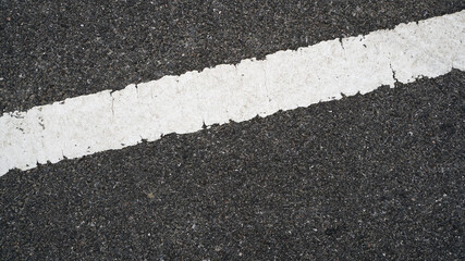 Fototapeta premium Surface rough and wet of asphalt after the rain, Grey with white line on the road and small rock, Texture Background, Top view
