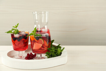 Delicious Red Sangria and ingredients on white wooden table, space for text