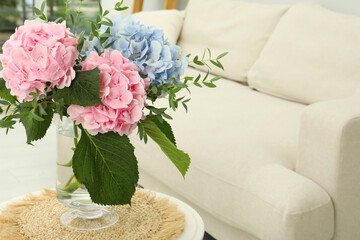 Bouquet with beautiful hortensia flowers on table in living room. Space for text