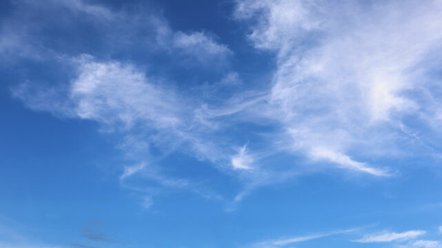 White cirrus clouds scattered in the sky. Streaks of white clouds lightly lit up the blue sky. selective focus