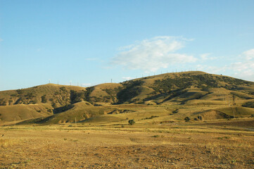 Fototapeta na wymiar Sand hills, mountains. There are windmills on sandy mountain. Crimea. The road to Cape Meganom.