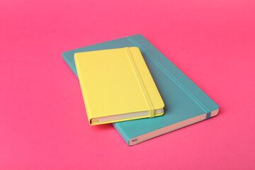 New stylish colorful planners on pink background