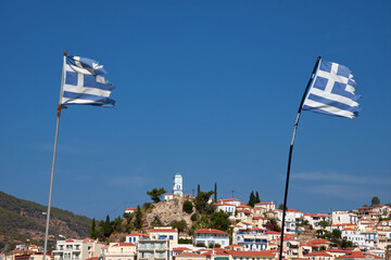 Griechische Flagge, im Hintergrund die Insel Poros.