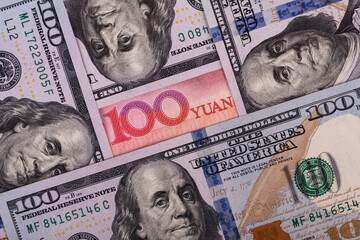 Overlapping fragmentary 100 Chinese yuan and 100 US dollar bills