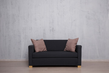 Modern sofa with copy space over concrete wall
