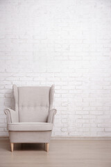 Modern armchair with copy space over brick wall