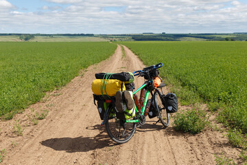 Fototapeta na wymiar Traveler's bike standing on a field road. Cycling travel.