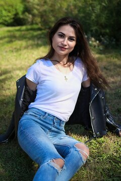 Hübsche junge Frau mit Lederjacke und Jeans
