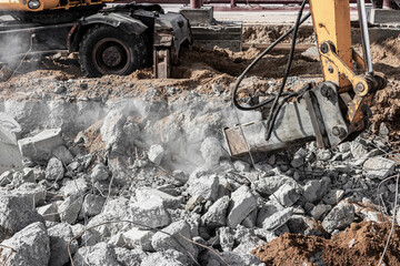 Fototapeta premium Professional demolition of reinforced concrete structures using industrial hydraulic hammer with excavator. Rods of metal fittings. Wreckage and crumbles of concrete.