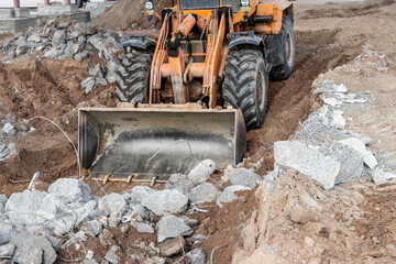 A front-end loader at a construction site removes debris from reinforced concrete. Collection and...