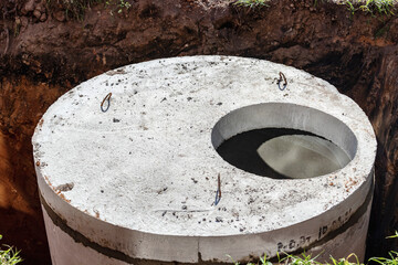 Installation of concrete sewer wells in the ground at the construction site. The use of reinforced...