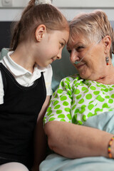 Supporting granddaughter touching forehead with elderly grandmother showing love during clinical...