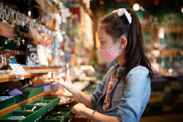 お店でアクセサリーを選ぶ少女