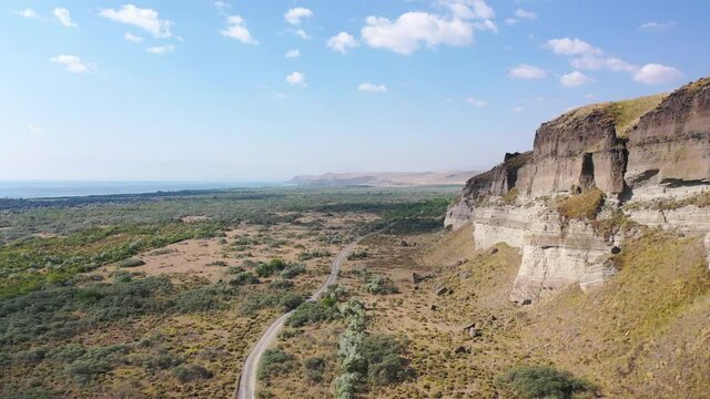 Aerial view road near sand mine.  Aerial view road near desert field․ Aerial footage road between field with dry grass and small trees. It's located near Sevan Lake, Armenia. 