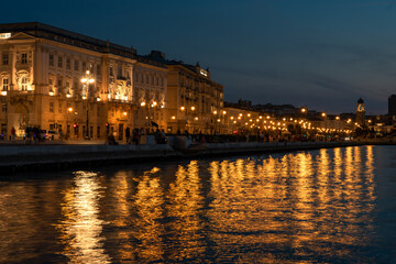 Fototapeta na wymiar sea coast in Trieste Italy with beautiful illuminated buildings and reflection on the water
