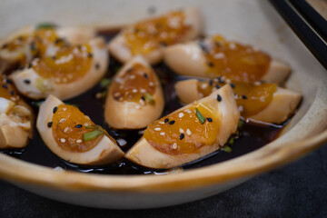 Soy pickled eggs, sliced, with chopsticks