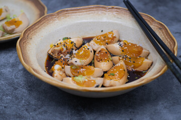 Soy pickled eggs, sliced, with chopsticks