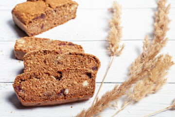 Gluten-free homemade bread on a light wooden background. Ears of cereals
