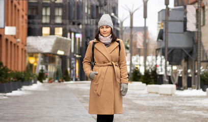 Obraz premium Outdoor portrait of woman in coat walking down the street