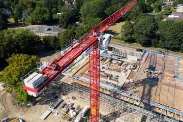 Aerial view of a tall crane lifting items on a construction site