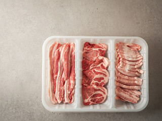 Assorted pork cuts on trays for packaging