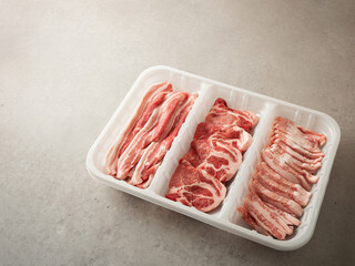 Assorted pork cuts on trays for packaging