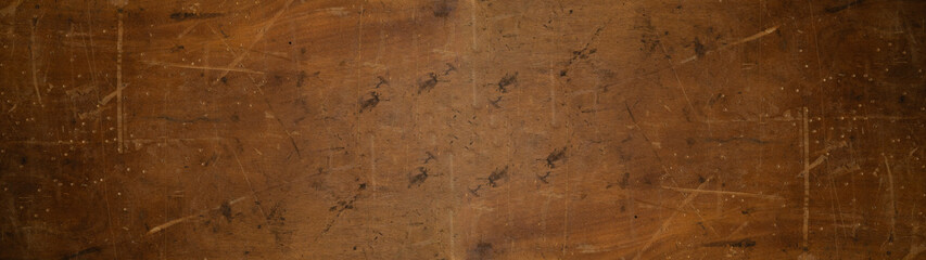 old brown rustic weathered scratched dirty dark wooden table wall texture - wood timber background panorama banner.