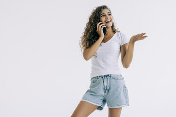 Portrait of a happy young woman talking on the phone isolated on a white background
