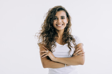 Portrait of a happy woman standing with arms folded on a white background