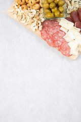 Charcuterie board salami olives cheese blue nuts and taralini