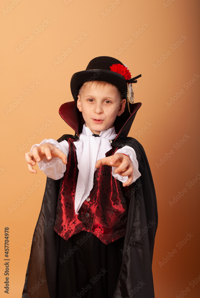 Wall mural an American-looking boy in a Dracula costume with a black hat depicts a mummy on Halloween with his hands in front of him in the camera.