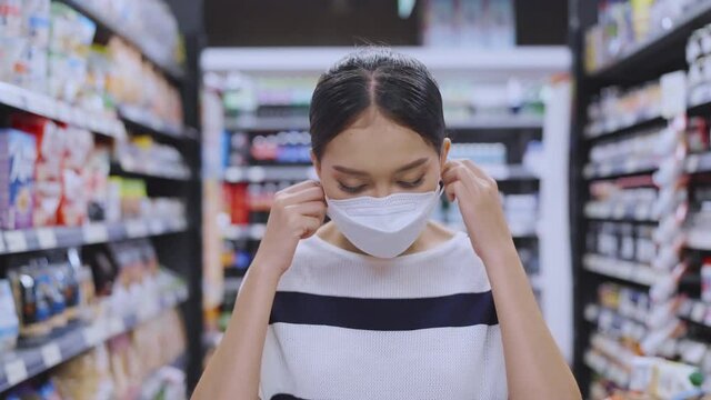 young asian adult smiling and happiness hand remove taking off face mask virus protecting after covid lockdown is over end of quarantine,asian female smile after take face mask off