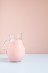 milk in jug on pink background