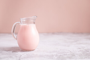 milk in jug on pink background