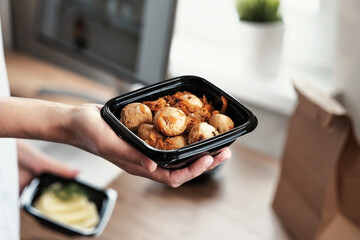 Takeaway Food. Women's hands hold a bowl of meat balls