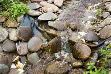 A stream flows over the stones in the garden