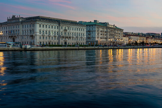 sea coast in Trieste Italy with beautiful illuminated buildings and reflection on the water