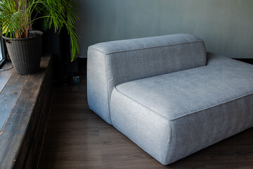 soft upholstered light sofa with modules in the interior with a panoramic window
