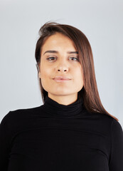 beautiful swarthy girl in a black turtleneck on a white background portrait full face looking at the camera